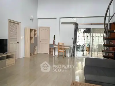 Spacious modern living room with high ceiling and spiral staircase