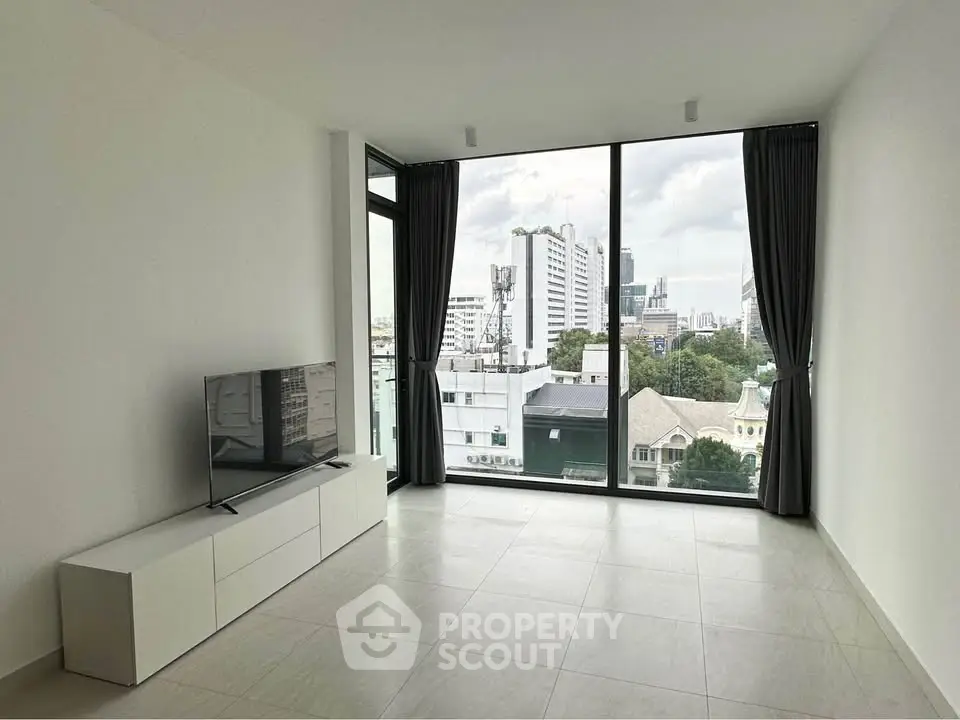 Modern living room with large windows and city view, featuring sleek TV stand and minimalist design.