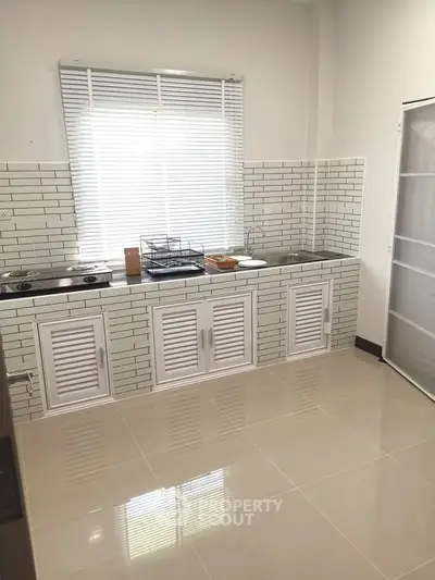 Modern kitchen with sleek white cabinetry and tiled backsplash