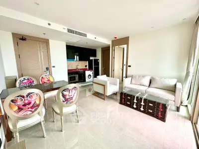 Modern living room with stylish furniture and open kitchen layout, featuring unique artistic chairs.