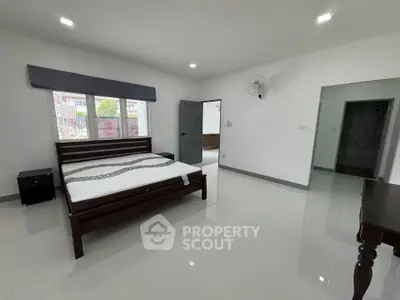 Spacious bedroom with modern furnishings and large windows in a contemporary home.