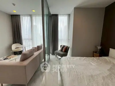 Modern bedroom with elegant decor and floor-to-ceiling windows offering natural light.
