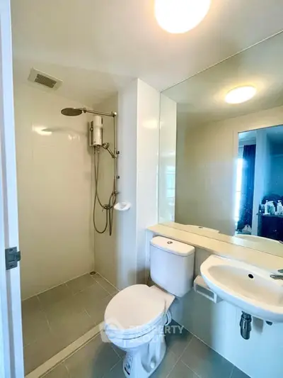 Modern bathroom with sleek fixtures and large mirror in a contemporary apartment.