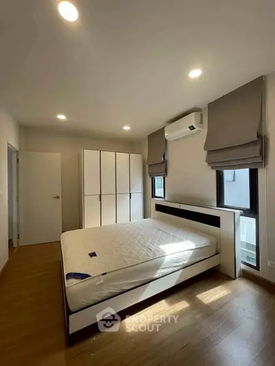 Modern bedroom with sleek design, featuring a comfortable bed, ample storage, and natural light.