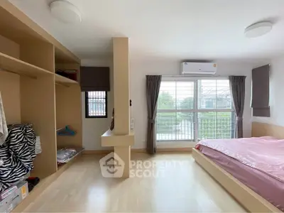 Spacious bedroom with large window and built-in closet, featuring a cozy bed and air conditioning.