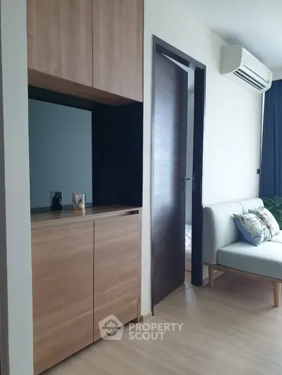 Modern living room with sleek wooden cabinetry and cozy seating area.