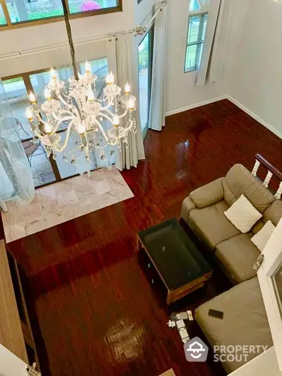 Elegant living room with chandelier and hardwood floors, spacious and inviting for luxury living.