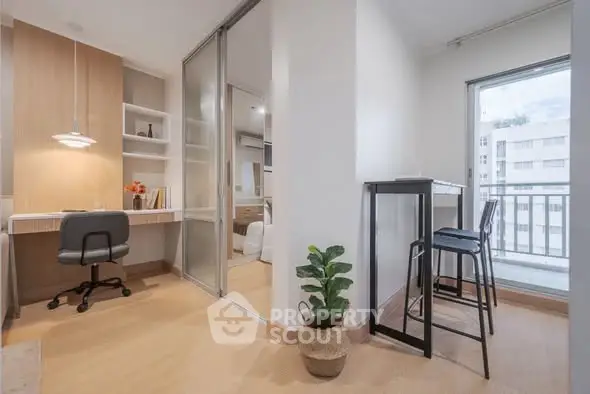Modern apartment interior with study area and balcony view, featuring sleek design and natural light.