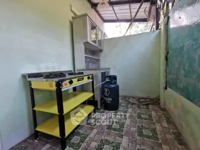 Compact outdoor kitchen with gas stove and storage shelves