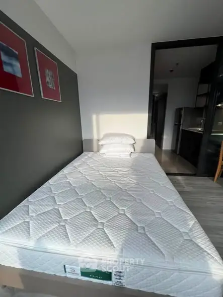 Modern bedroom with minimalist design and natural light, featuring a comfortable bed and sleek decor.