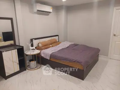 Modern bedroom with stylish decor and air conditioning, featuring a comfortable bed and sleek furniture.