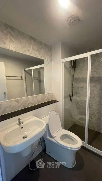 Modern bathroom with sleek design featuring a shower enclosure and stylish tiles.
