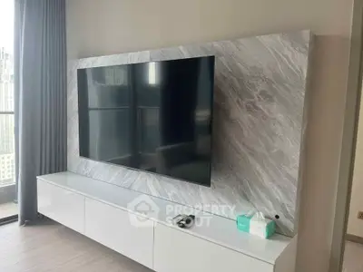 Modern living room with sleek TV setup and marble accent wall
