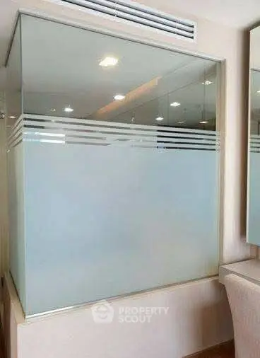 Modern bathroom with frosted glass partition and elegant lighting