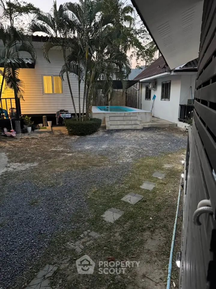 Charming backyard with small pool and lush greenery, perfect for relaxation and outdoor enjoyment.