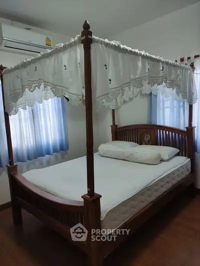 Charming bedroom with elegant four-poster bed and soft natural lighting.