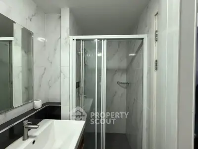 Modern bathroom with sleek shower and elegant marble tiles