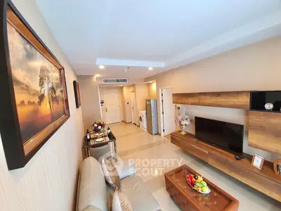 Modern living room with stylish decor and open layout, featuring a cozy sofa and wall-mounted TV.