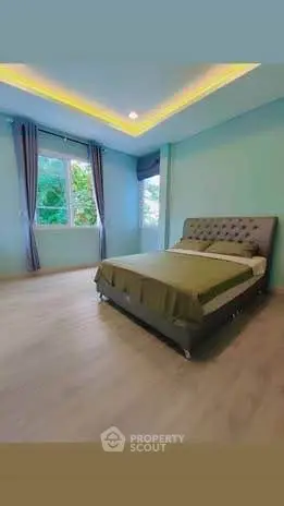 Spacious bedroom with modern design and large windows for natural light.