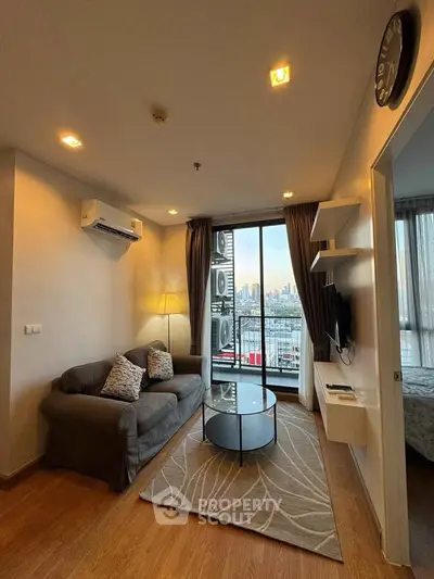 Modern living room with city view, cozy sofa, and stylish decor in a high-rise apartment.