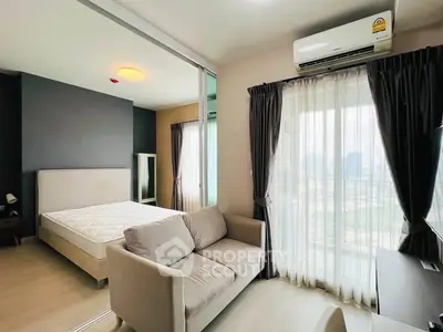 Modern bedroom with large window, cozy sofa, and air conditioning in a stylish apartment.