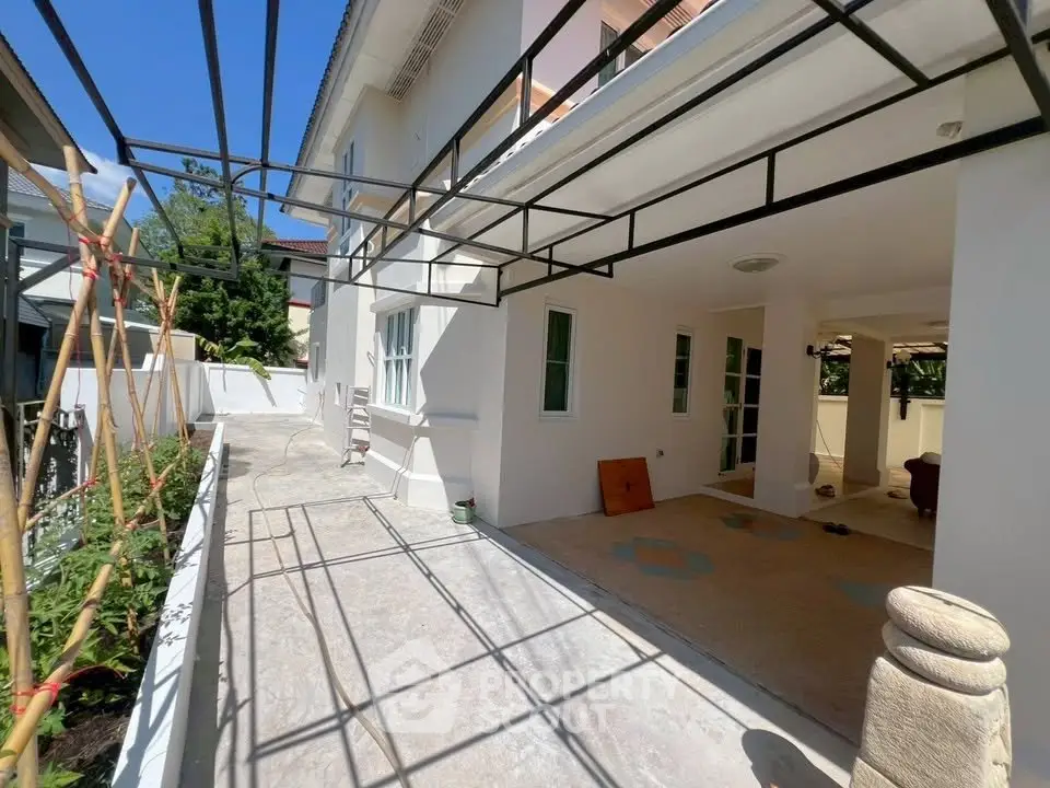 Spacious modern house exterior with covered patio and garden area, perfect for outdoor living.