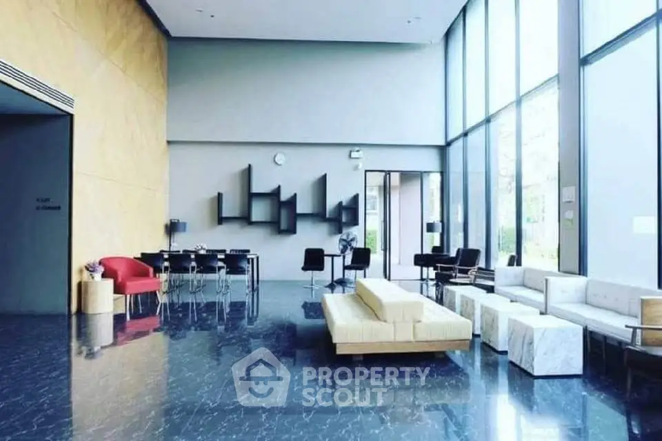 Modern lobby with high ceilings, stylish seating, and large windows offering natural light.