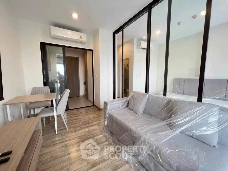 Modern living room with glass partition and stylish furniture in a contemporary apartment.