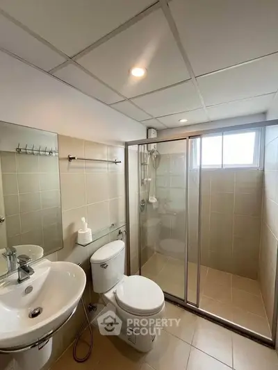 Modern bathroom with glass shower and sleek fixtures in a contemporary home.