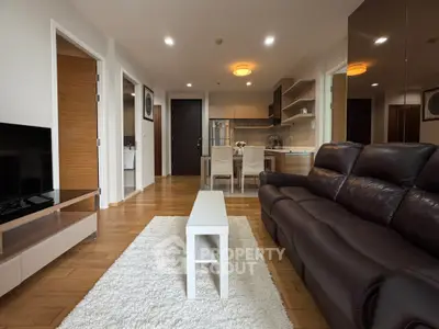 Modern living room with sleek leather sofa and open kitchen layout