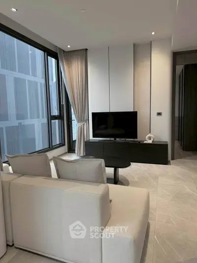 Modern living room with sleek design and large windows offering city views.