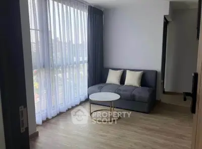 Modern living room with large window and stylish sofa, perfect for relaxation.