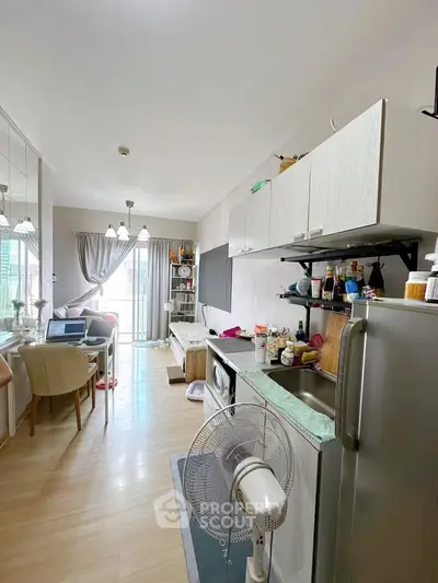 Modern open-layout kitchen and living area with natural light and stylish decor.