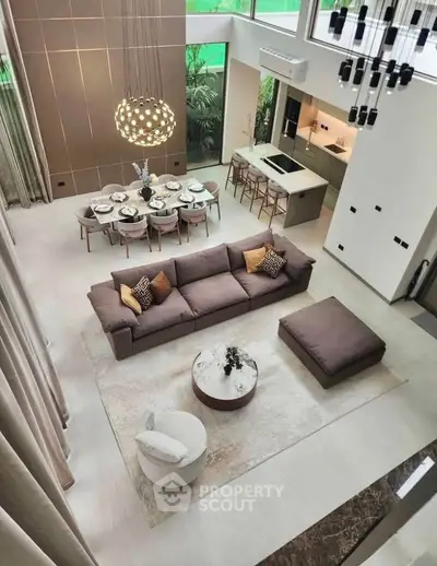 Luxurious open-plan living room with high ceilings and modern kitchen