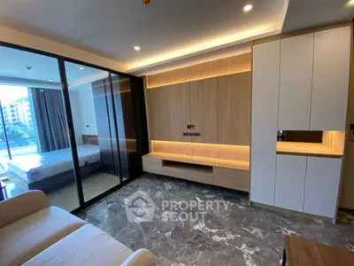 Modern living room with marble flooring and sliding glass doors to bedroom