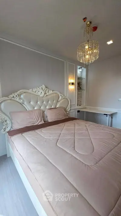 Luxurious bedroom with elegant chandelier and ornate headboard, perfect for sophisticated living.