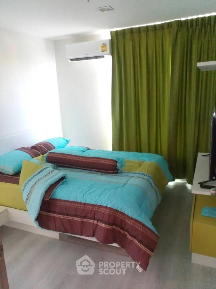 Cozy bedroom with vibrant bedding and air conditioning, perfect for relaxation.