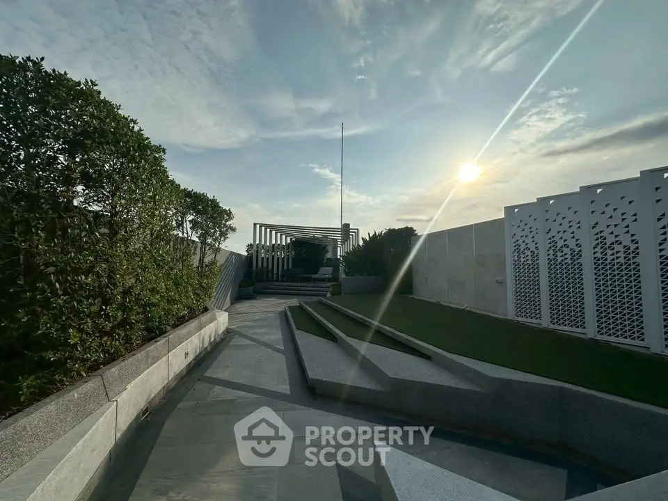 Stunning rooftop garden with modern design and lush greenery under a bright sky.