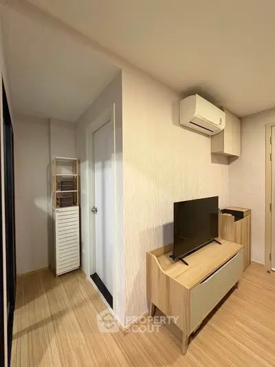 Modern living room with wooden flooring and sleek TV unit