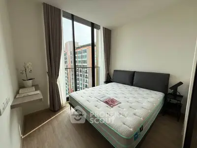 Modern bedroom with large window and city view, featuring a comfortable bed and elegant decor.