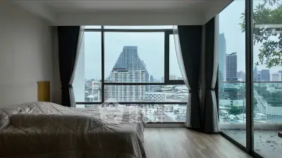 Luxurious bedroom with stunning city view and floor-to-ceiling windows in modern apartment.
