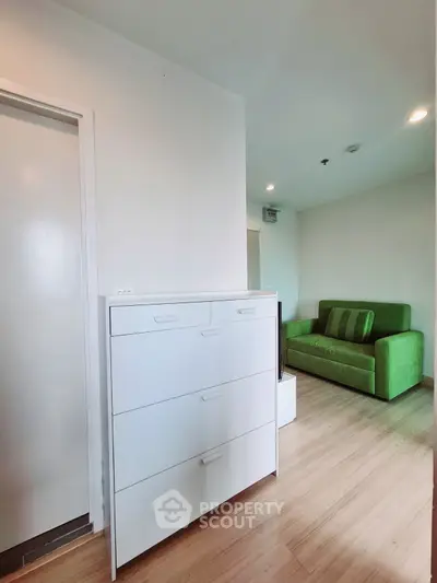 Modern living room with green sofa and sleek white storage unit