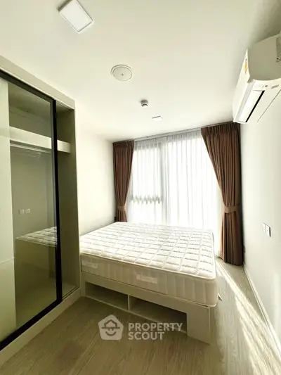 Bright and cozy bedroom with large window and modern furnishings