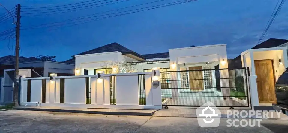 Modern single-story house with stylish exterior lighting and gated entrance at dusk.