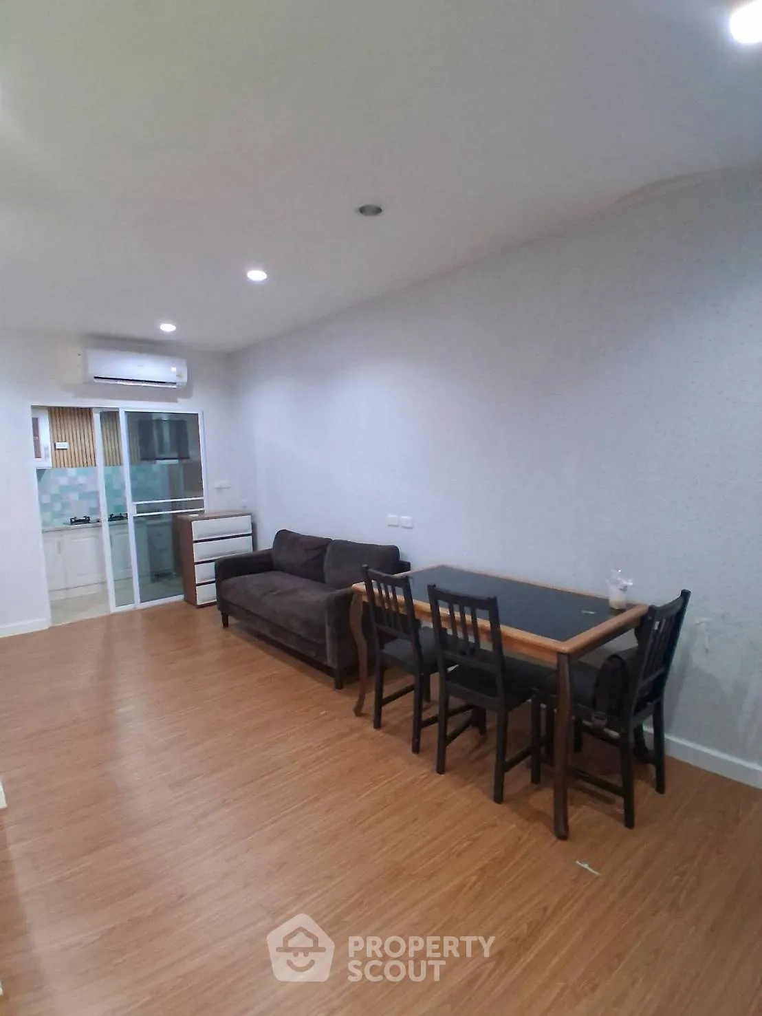 Spacious living room with modern furniture and wooden flooring, perfect for relaxation and entertaining.