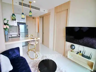 Modern living room with open kitchen, stylish decor, and cozy seating area.