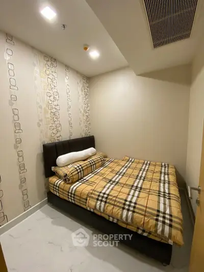 Cozy bedroom with modern decor and stylish bedding in a real estate property.