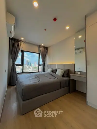 Modern bedroom with city view, featuring sleek design and ample natural light.