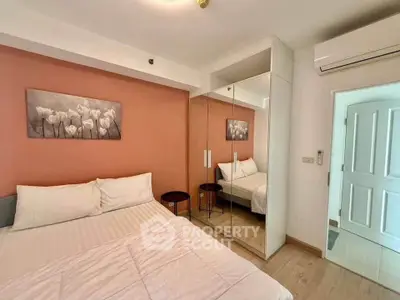 Cozy bedroom with mirrored wardrobe and modern decor in a stylish apartment.