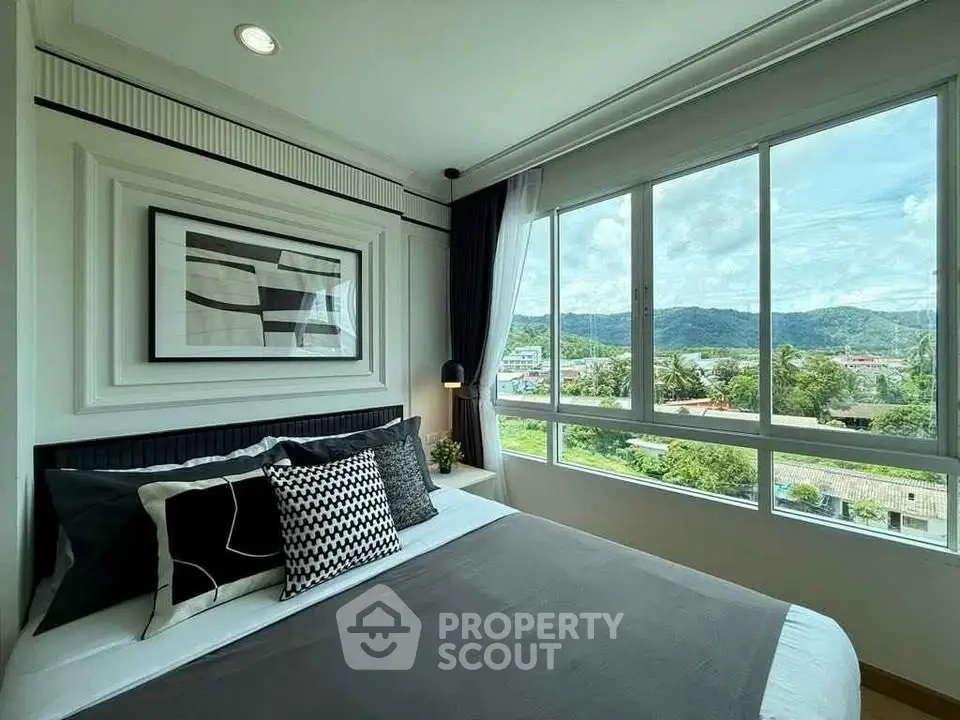 Modern bedroom with large windows offering scenic mountain views